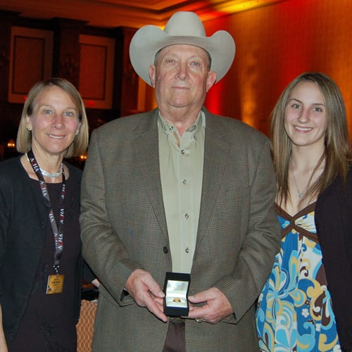Denny Hassett, pictured here with Debby and Morgan Brehm, the Don Burt Professional Horseman of the Year award. Photo © GoHorseShow.com